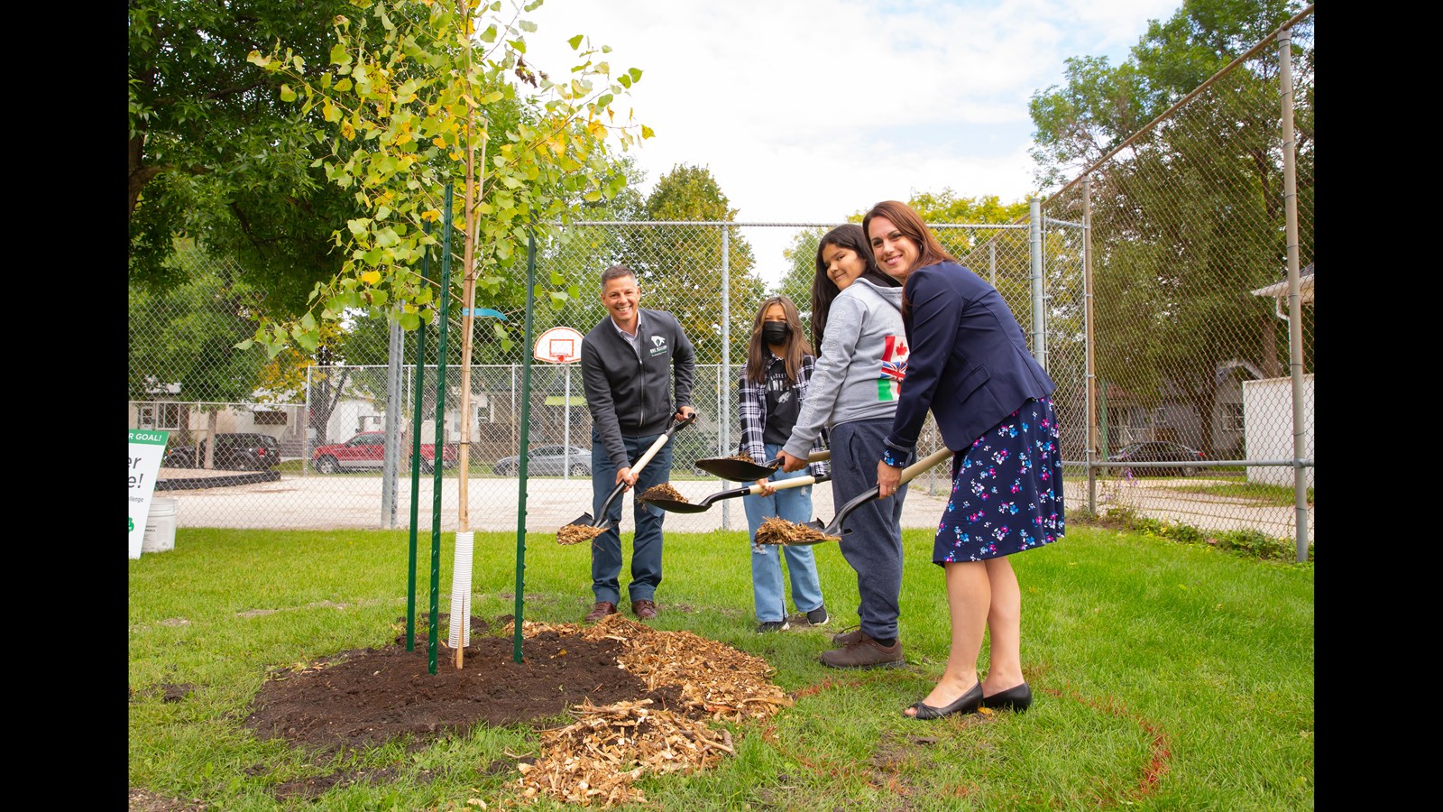 Mayor Brian Bowman, Principal Jennifer Cox and students shovel mulch as part of the Sept. 21 tree-planting ceremony.